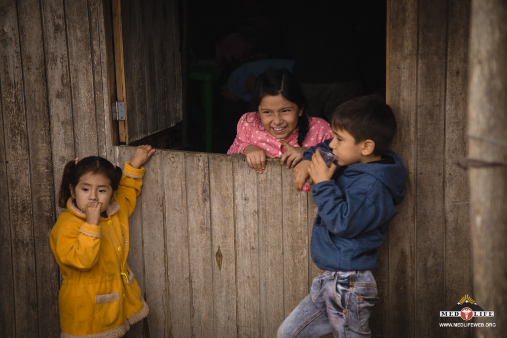 A group of friends chat during clinic while their parents are attended to by MEDLIFE doctors.